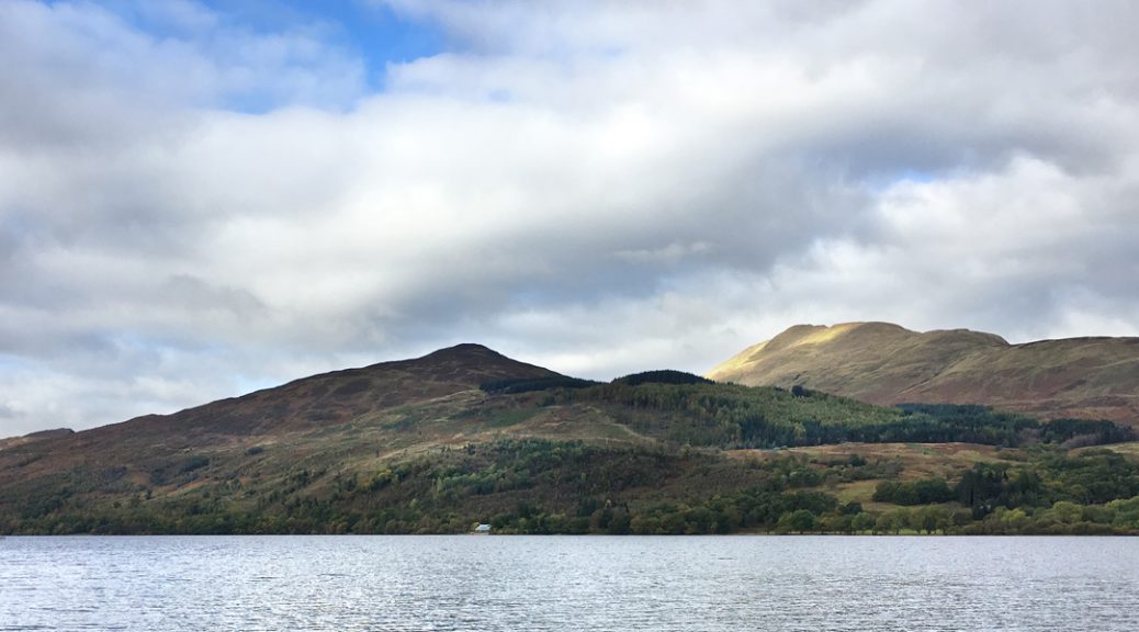 View across Loch Venachar to the Venachar Lochside café against backdrop of Ben Ledi